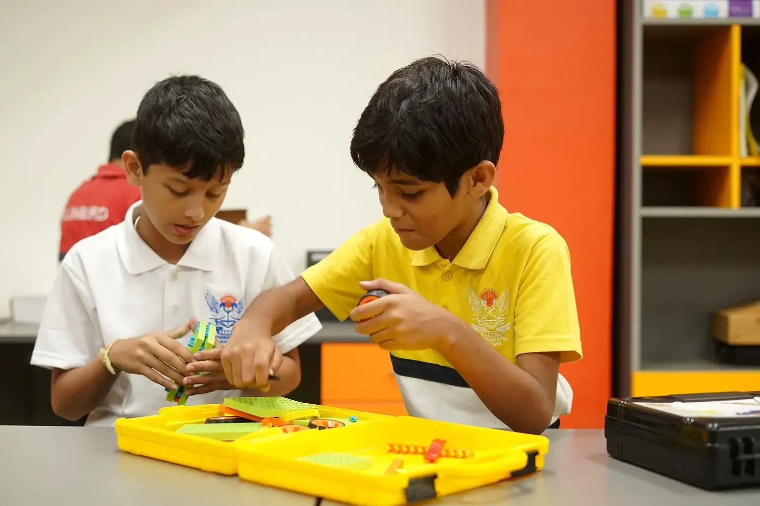 Two Vandya International School students assembling a robotics kit in the school lab
